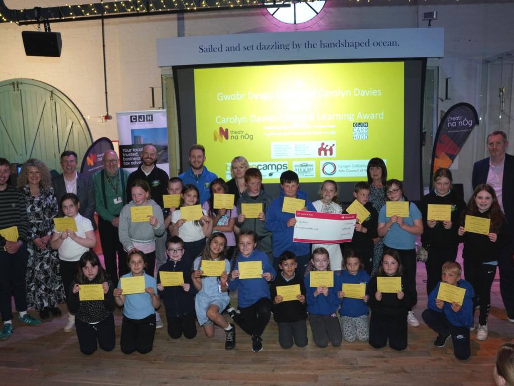 Students from Blaenymaes Primary School posing with their first place certificates, trophy and large cheque.