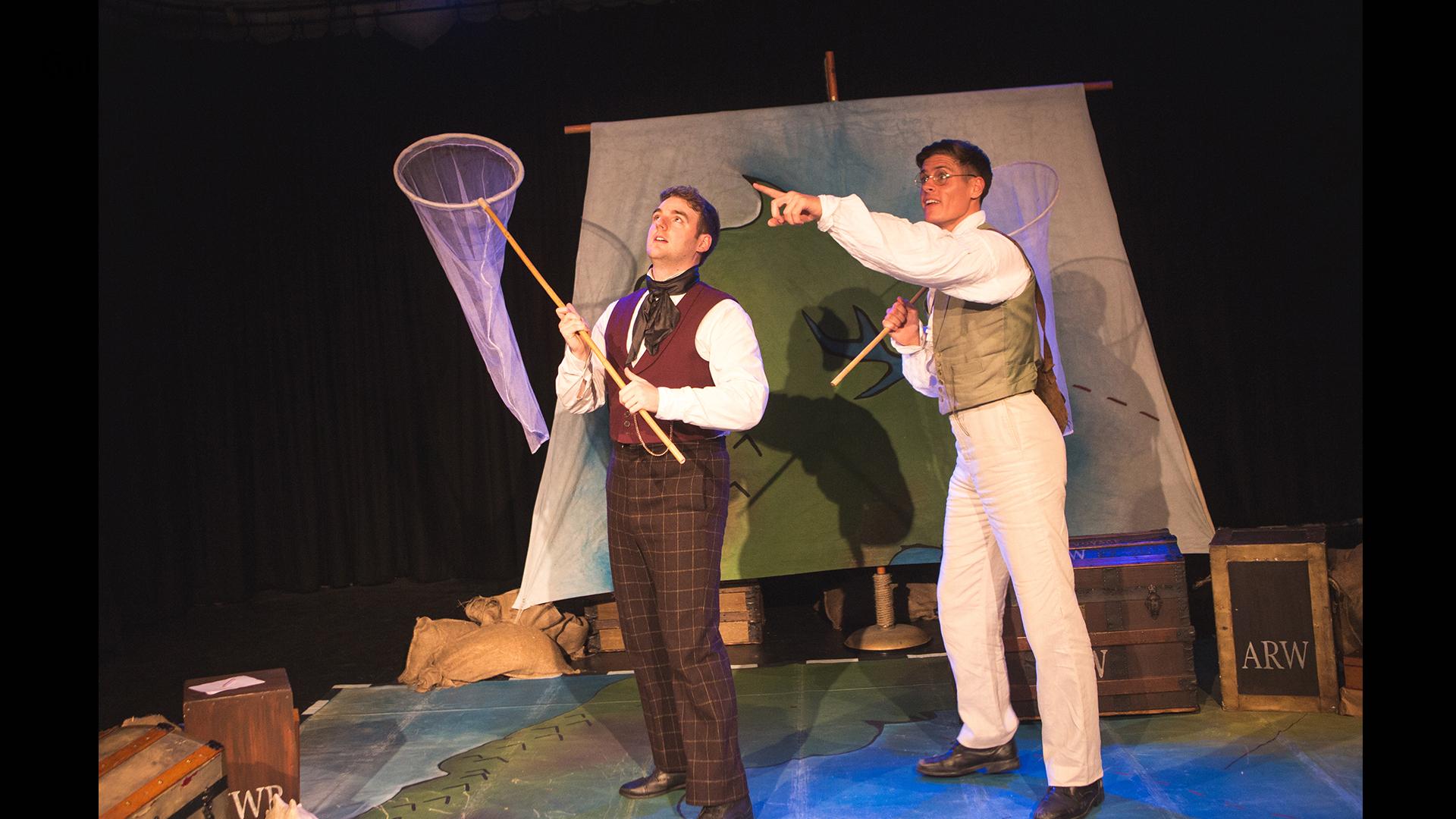Two men dressed as Victorian explorers holding butterfly catching nets