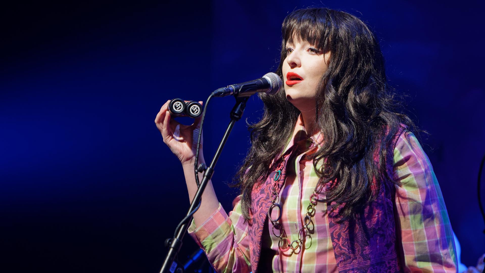 Actor Caitlin Lavagna singing and playing a shaker