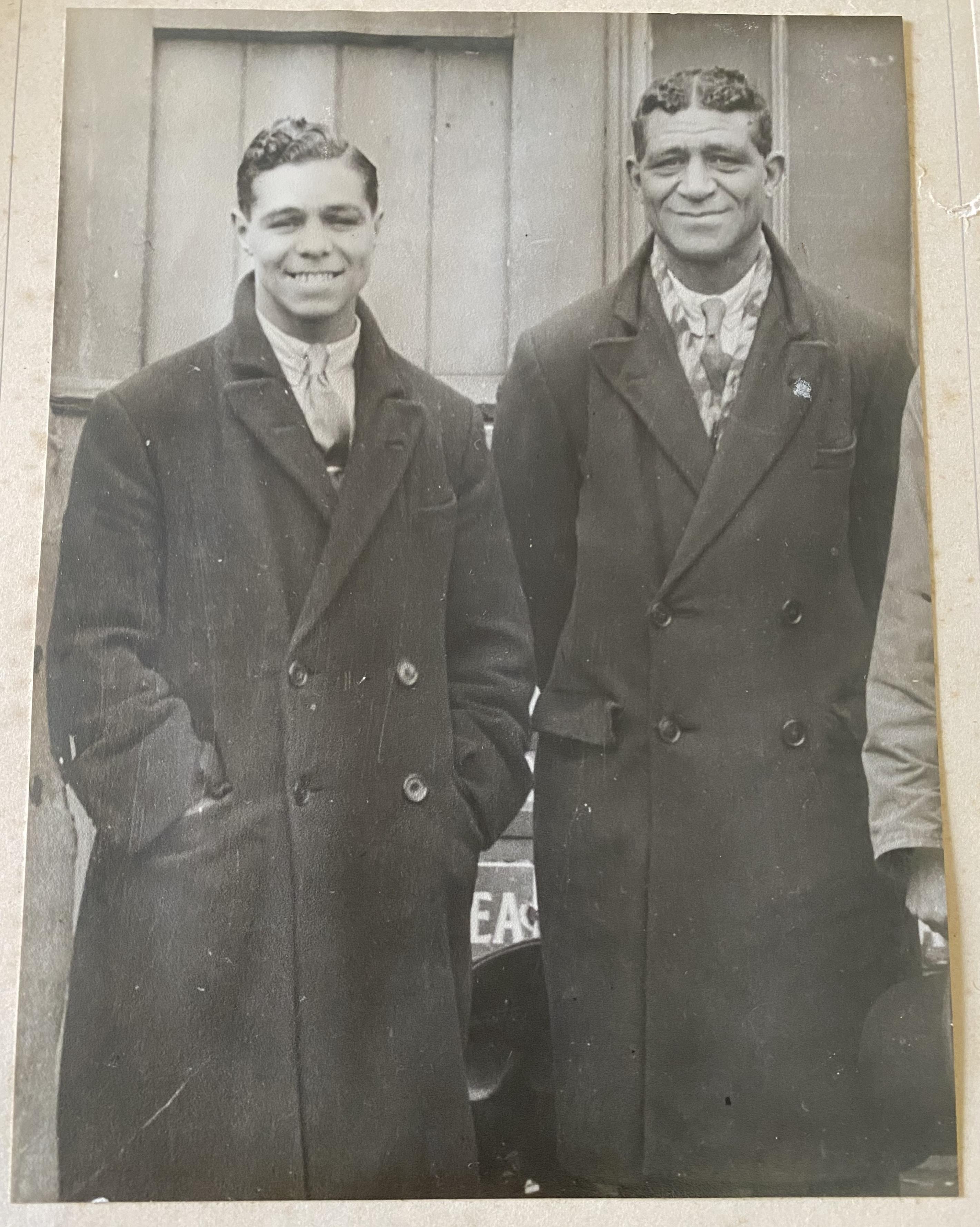 Photo of two black men in dark coats