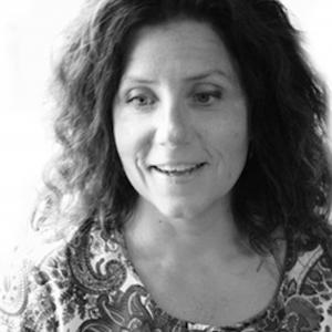 Woman with long dark hair wearing a patterned top - picture in black and white