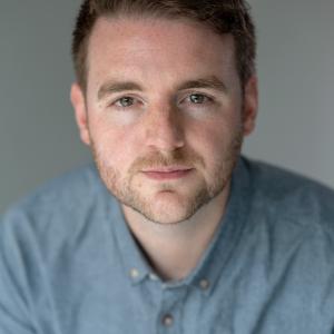 Man with brown hair in blue shirt