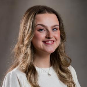 Siân's headshot - a white woman in her mid twenties with light brown, long curly hair